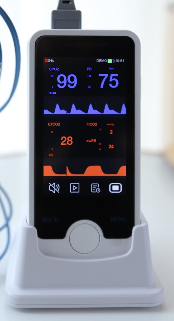 VE4 vital signs monitor docked in its charging base with the SpO2 sensor cable connected